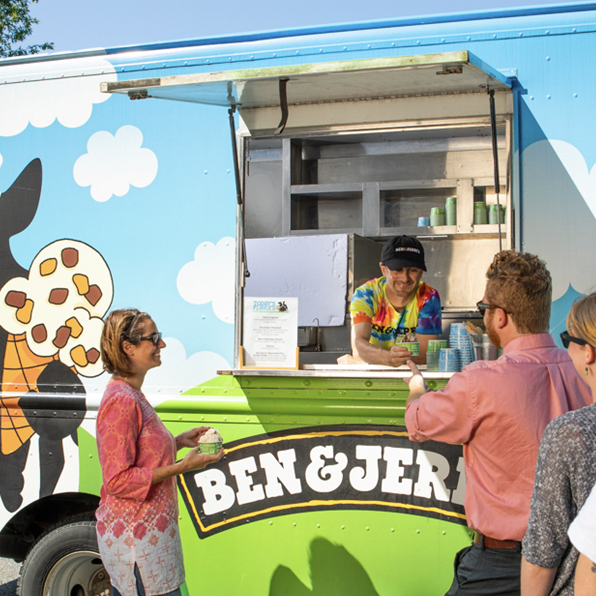 People standing in front of an ice cream catering truck
