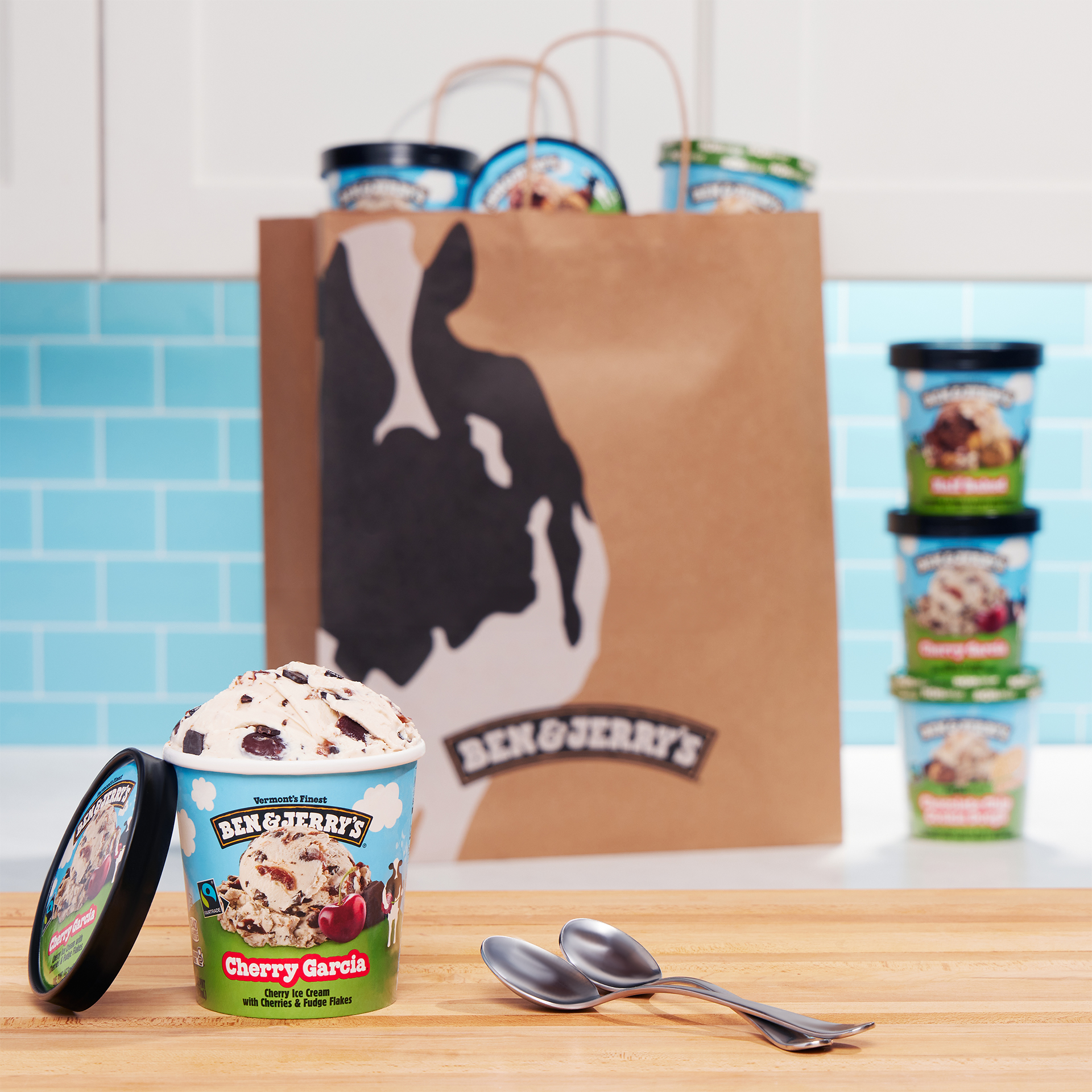 An open pint of ice cream on a table in front of a shopping bag