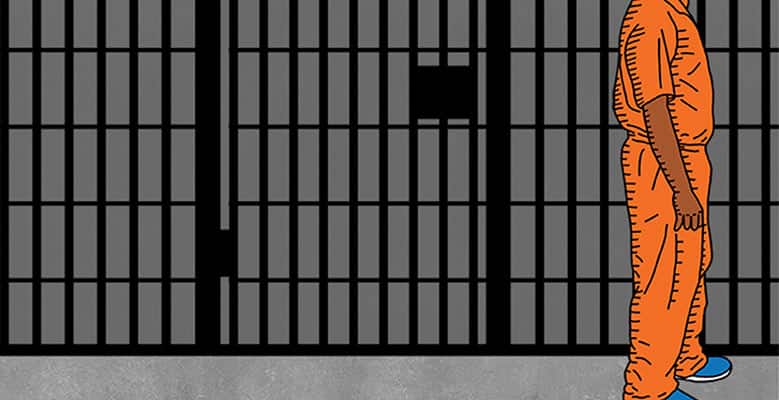 Person in an orange prison jumpsuit in front of a prison door.