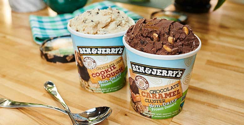 Pints of Ben & Jerry's Chocolate Chip Cookie Dough and Chocolate Caramel Cluster Non-Dairy on a kitchen counter.